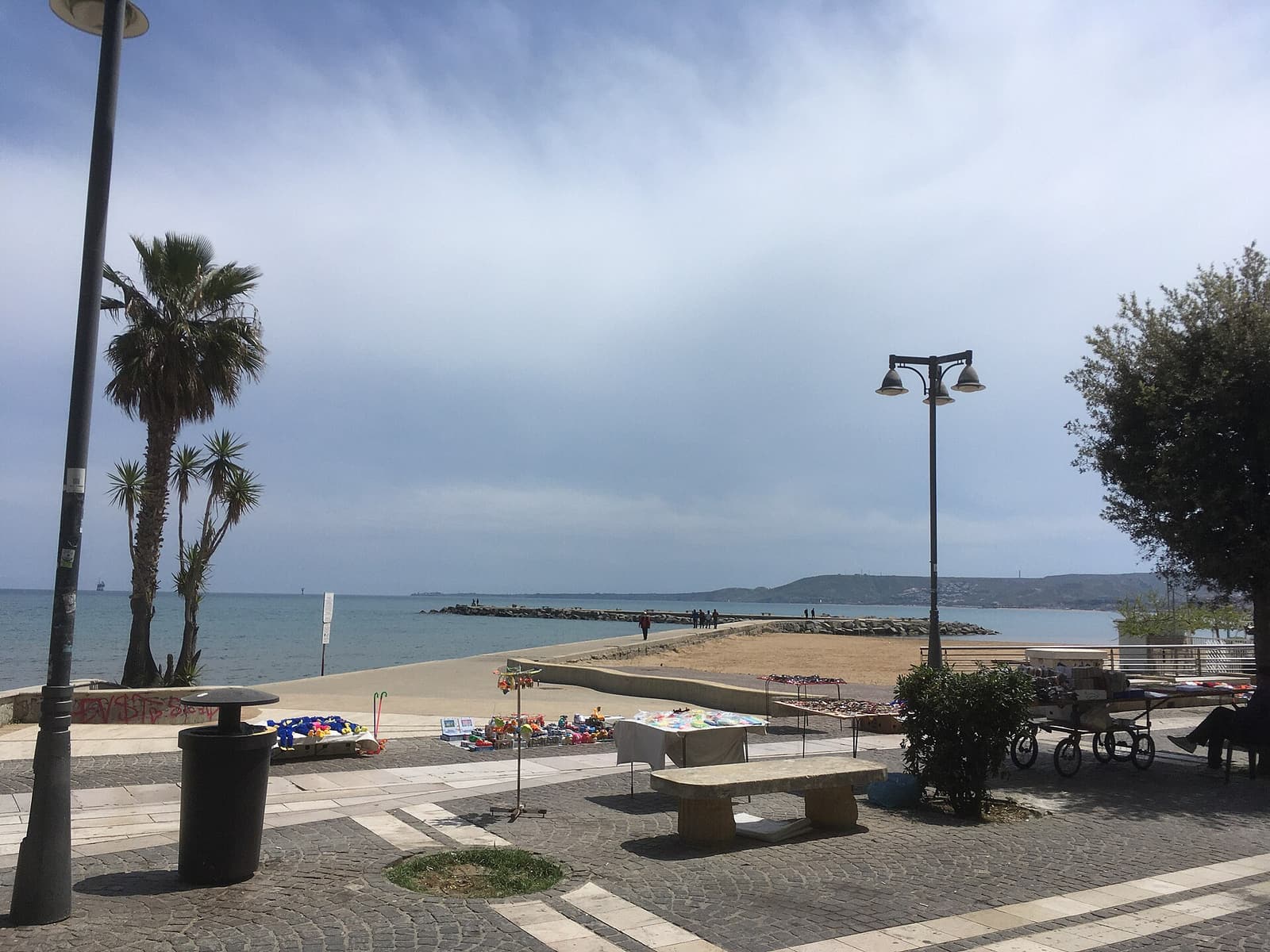 Palm trees and a sandy beach beside the seafront promenade in Crotone