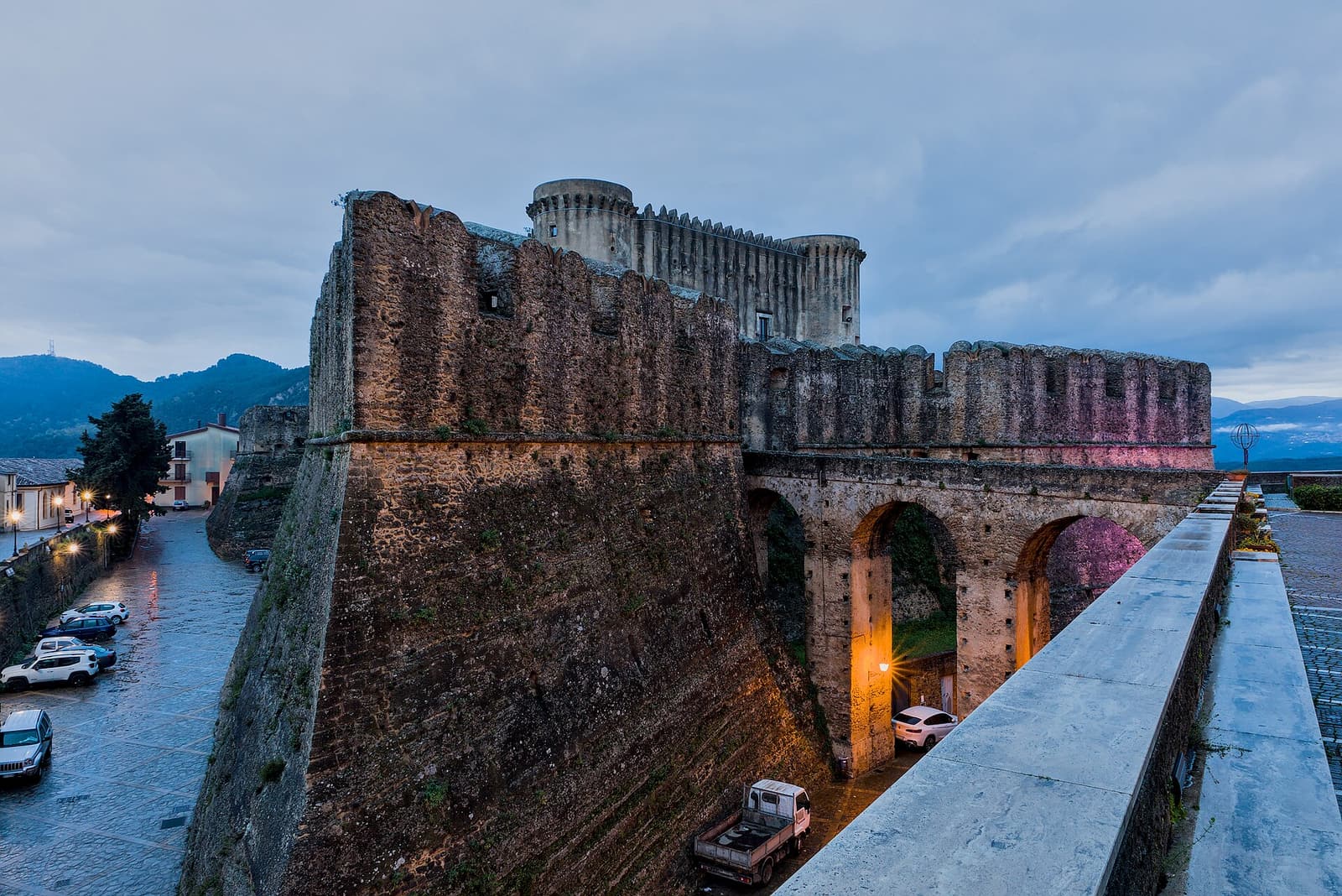 The walls and towers of the castle of Santa Severina at dusk